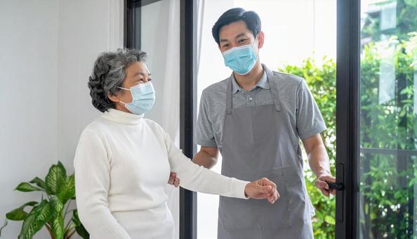 見守り訪問で高齢者住宅を訪問する男性 見守り訪問で高齢者住宅を訪問する男性の写真