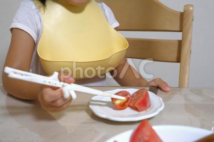 トマトをトレーニング箸で食べる子ども 子ども,食事,箸の写真素材