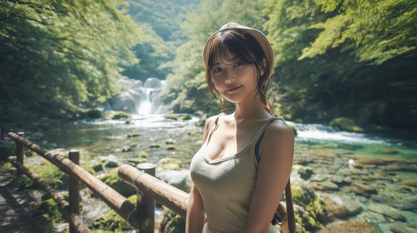 夏の深緑と渓流沿いの遊歩道と若い女性 夏の深緑と渓流沿いの遊歩道と若い女性の写真