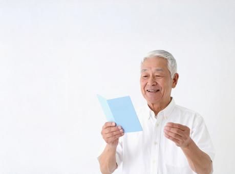手帳を見る笑顔の高齢男性 手帳を見る笑顔の高齢男性の写真
