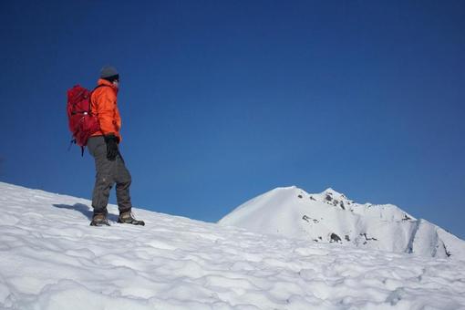 快晴の雪山を歩く登山者(男性) 快晴の雪山を歩く登山者(男性) 雪山登山,雪景色,冬の写真素材