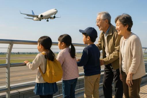 展望デッキで飛行機を待つ子ども達と祖父母 展望デッキで飛行機を待つ子ども達と祖父母の写真
