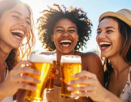 ビールを持って楽しむ女性たち ビールを持って楽しむ女性たちの写真