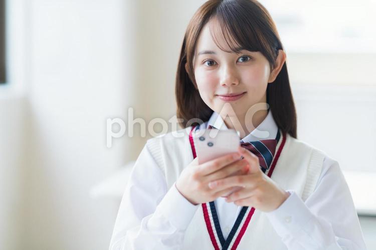 教室で勉強する学生 高校生,スマホ,笑顔の写真素材