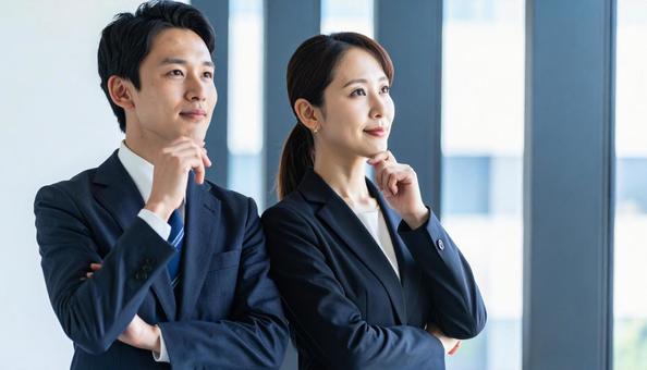 考えごとをする男女2人のビジネスパーソン 考えごとをする男女2人のビジネスパーソンの写真