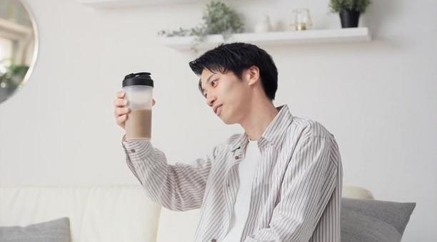 リビングでプロテインを見るアジア人男性 プロテイン,見る,男性の写真素材