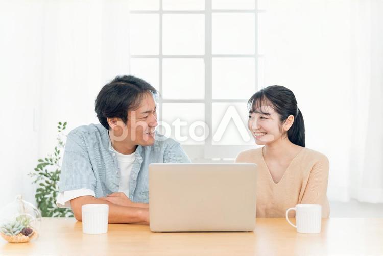 ノートパソコンを見る夫婦（笑顔） パソコン,光テレビ,動画の写真素材