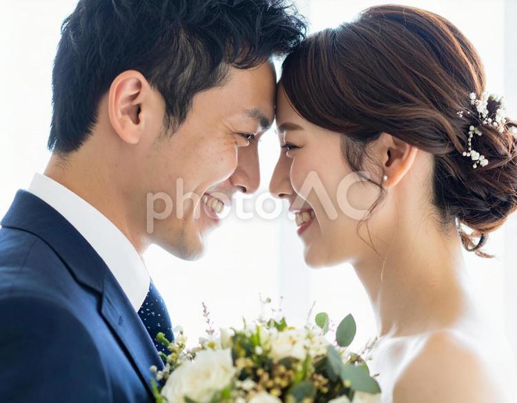 額を寄せ合う新郎新婦の幸せな笑顔 結婚,ウェディング,新郎新婦の写真素材
