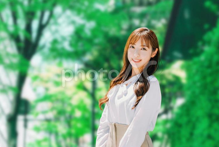 新緑の街路樹に立つ笑顔のビジネスウーマン 女性,ビジネス,ビジネスウーマンの写真素材