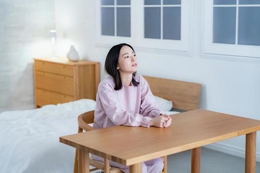 椅子に座り考え事をする女性 悩み,不眠,若いの写真素材
