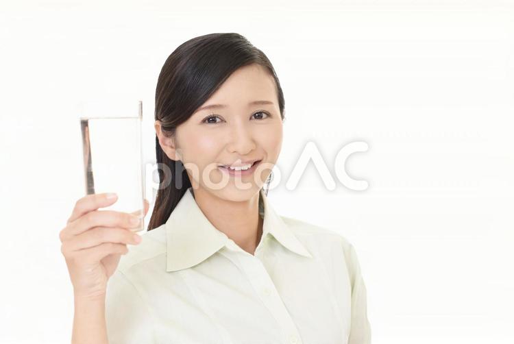 お水の入ったグラスを持つ笑顔の女性 女性,女,笑顔の写真素材