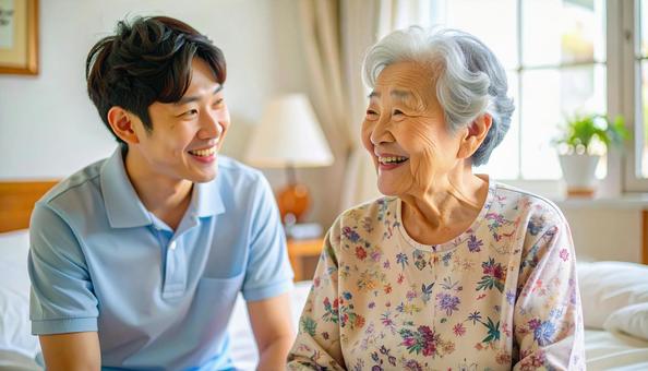 笑顔で話をする男性介護士と高齢女性の写真