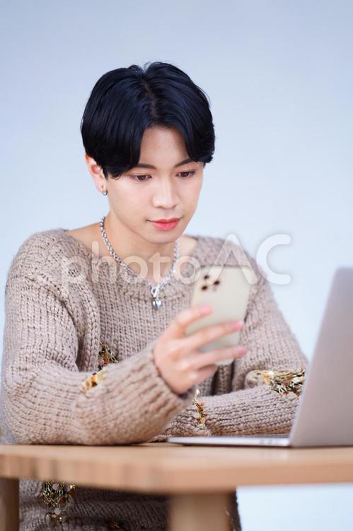 スマホを見ている日本人男性 男性,ノートパソコン,操作の写真素材