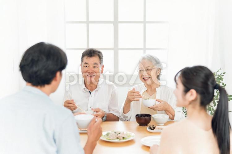 楽しい食事をする老夫婦と若い夫婦（笑顔） 家族,食事,里帰りの写真素材
