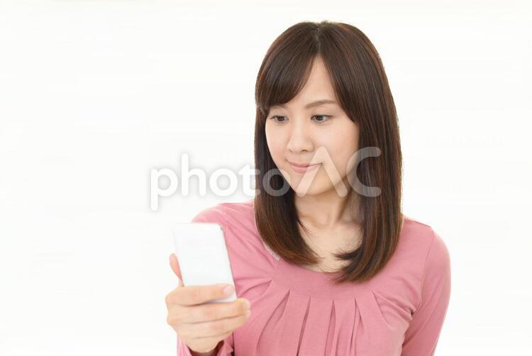 スマートフォンを持つ笑顔の女性 女性,スマートフォン,女の写真素材