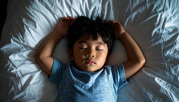 両手をあげて熟睡する男の子 両手をあげて熟睡する男の子の写真