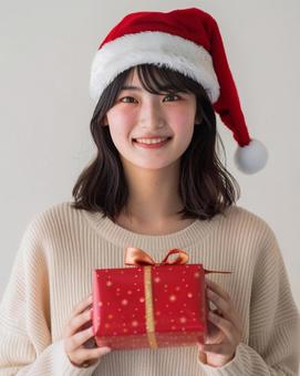 クリスマス プレゼントを持つ女性 クリスマス プレゼントを持つ女性の写真