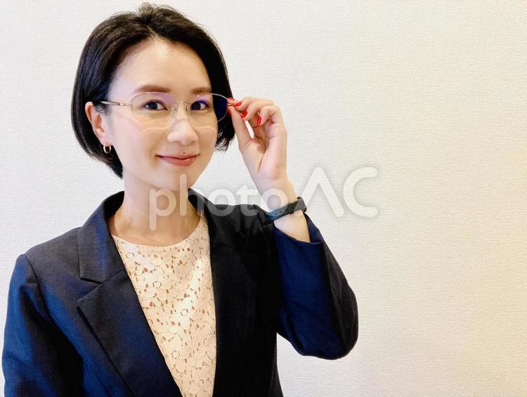 笑顔でメガネを触るビジネスウーマン 日本人,女性,笑顔の写真素材