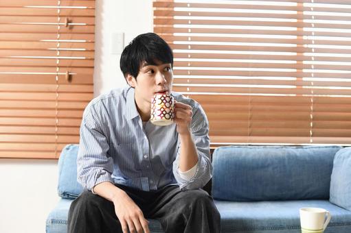 Relaxing young Asian man drinking a drink indoors, phong cách sống, người, ngồi, JPG