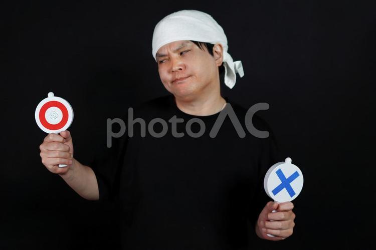 丸バツの札を持つ男性 男性,丸印,バツ印の写真素材