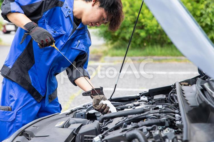 作業服を着た男性が車の整備をする 車,作業着,作業服の写真素材