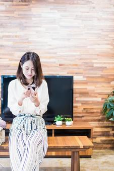 リビングでスマホを使う主婦 家,アプリ,webの写真素材