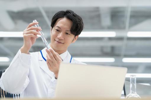 実験をする白衣の若い男性研究者 研究,実験,サイエンスの写真素材