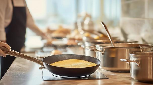 フライパンでオムレツを作るシェフの手元の写真