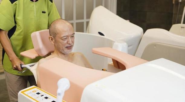 機械浴で入浴介助を受けるアジア人高齢者 高齢者,機械浴,入浴の写真素材