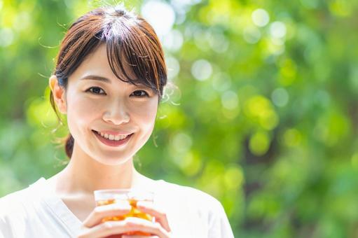 アイスコーヒーを手に微笑む女性の写真