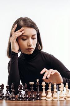 チェスの駒と肘をつく女性(白背景) チェスの駒と肘をつく女性(白背景) チェス,駒,女性の写真素材