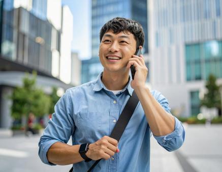 街中で電話をかける男性 街中で電話をかける男性の写真