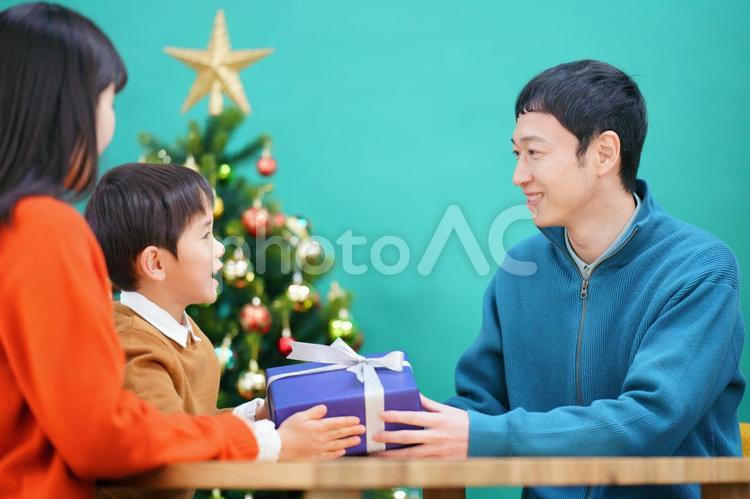 男性が男の子にプレゼントを渡す様子 男性,男の子,家族の写真素材