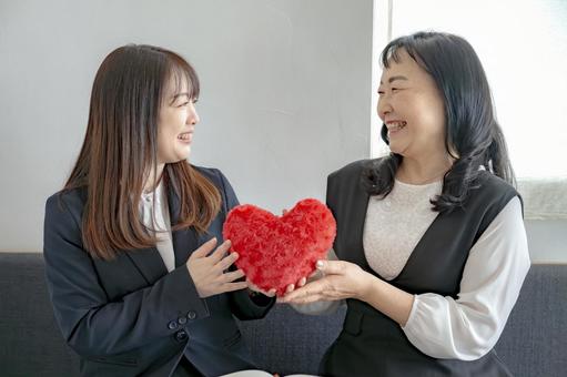 ハートを持つ笑顔の女性 ハートを持つ笑顔の女性 女性,笑顔,二人の写真素材