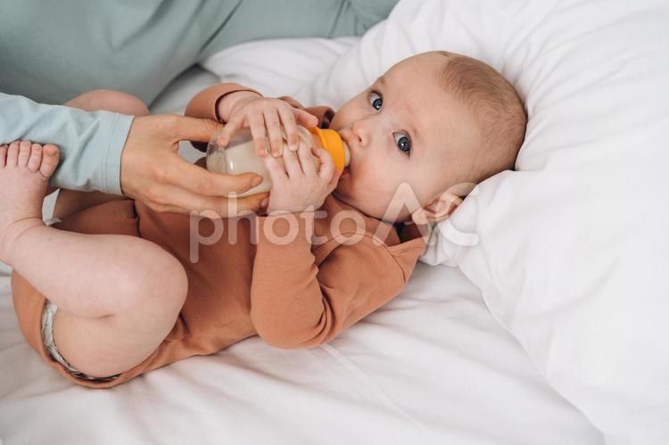 カメラ目線でミルクを飲む新生児 赤ちゃん,哺乳瓶,飲むの写真素材