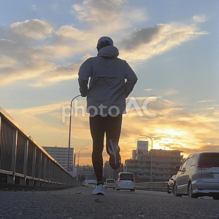 日の出を見ながら走る男性ランナー 男性,男,走るの写真素材