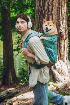 森の中で犬を背負う男性 男性,外国人,犬の写真素材