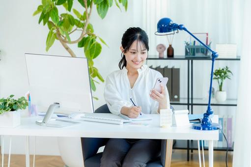 オフィスでスマホを持つビジネスウーマン スマホ,笑顔,ビジネスウーマンの写真素材