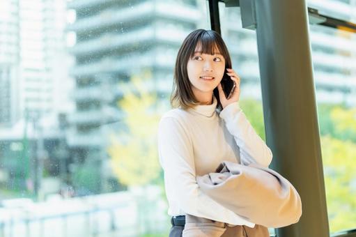 スマホで通話をする若い女性 女性,人物,秋の写真素材