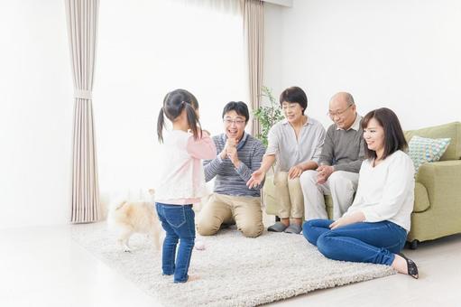お遊戯をする子供と仲良しの家族 お遊戯をする子供と仲良しの家族 祖父母,一人娘,舞台の写真素材