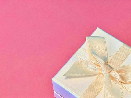 リボンつきギフトボックス（ピンク背景）の写真