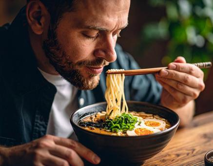 豚骨ラーメンを食べる男性 豚骨ラーメンを食べる男性の写真
