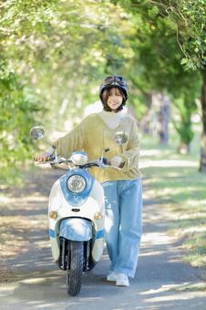 バイクに乗る若い女性 バイクに乗る若い女性 バイク,女性,スクーターの写真素材