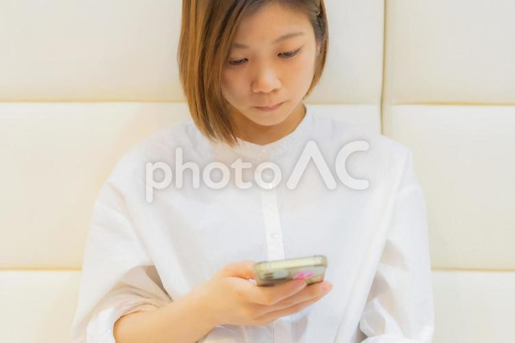 隙間時間にスマホで副業の仕事をする女性 スマホ,スマートフォン,携帯の写真素材