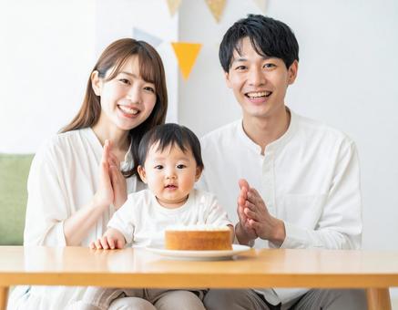 赤ちゃんの誕生日をお祝いする若い夫婦 赤ちゃんの誕生日をお祝いする若い夫婦の写真