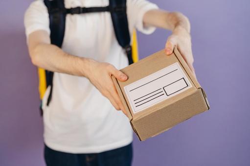 段ボール箱を渡す配達員の男性 配達,デリバリー,配送の写真素材