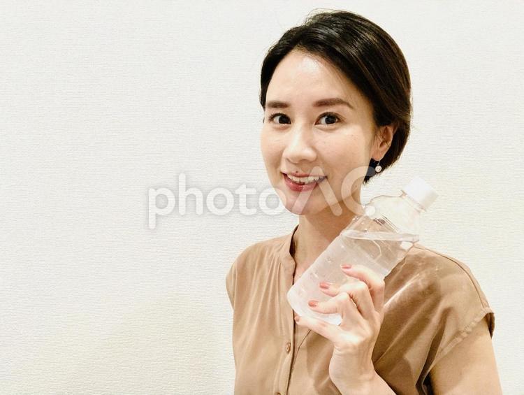 水のペットボトルを持つ黒髪の日本人女性 女性,笑顔,日本人の写真素材