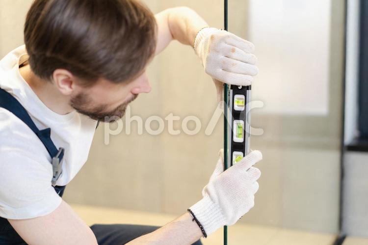 両手で水平器を持つ男性 男性,水平器,持つの写真素材