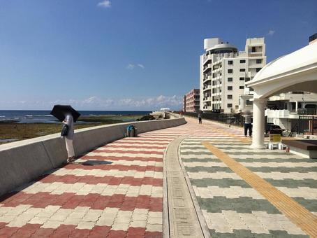 沖縄の浅瀬と海沿いの壁、遊歩道と街並み 沖縄,浅瀬,宮城海岸の写真素材