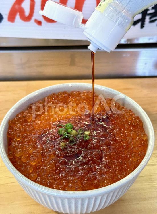 いくら丼　醤油をかける いくら丼,どんぶり,カウンターの写真素材